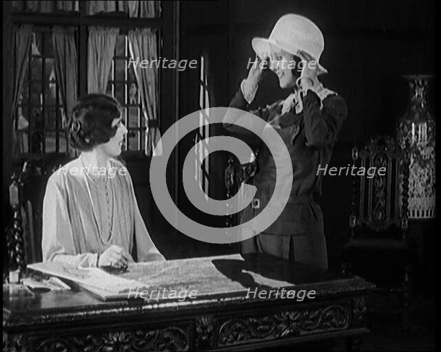 Female Civilian Trying a Hat in Front of Another Female Civilian, 1920. Creator: British Pathe Ltd.
