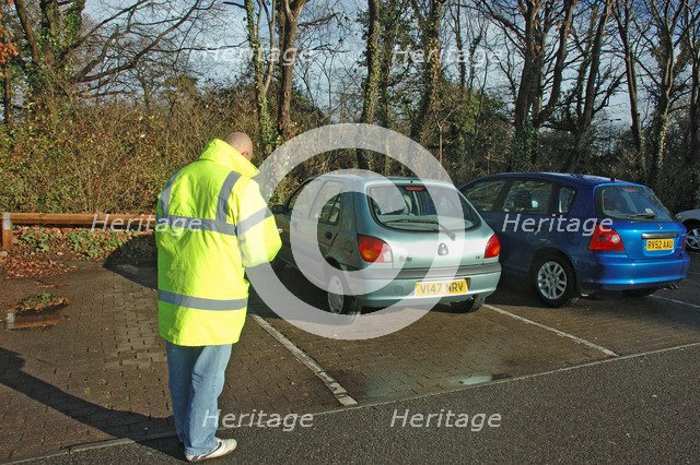 Car Park attendant recording car registration numbers. Artist: Unknown.