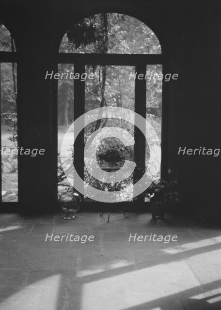 View through arched window into a courtyard, New Orleans or Charleston, South Carolina, c1920-c1926. Creator: Arnold Genthe.