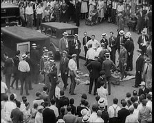 Crowded New York City Street Where Police and Ambulance Attend to Dead and Dying Victims..., 1932. Creator: British Pathe Ltd.