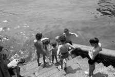 Children bathing in the River Thames, Tower Pier approach, Stepney, London, c1945-c1965. Artist: SW Rawlings
