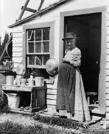 Elderly woman, standing at doorway, on Mackinac Island, Michigan, 1903. Creator: Frances Benjamin Johnston.