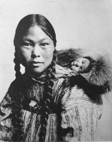 Eskimo mother with child on back, c1906. Creator: Lomen Brothers.