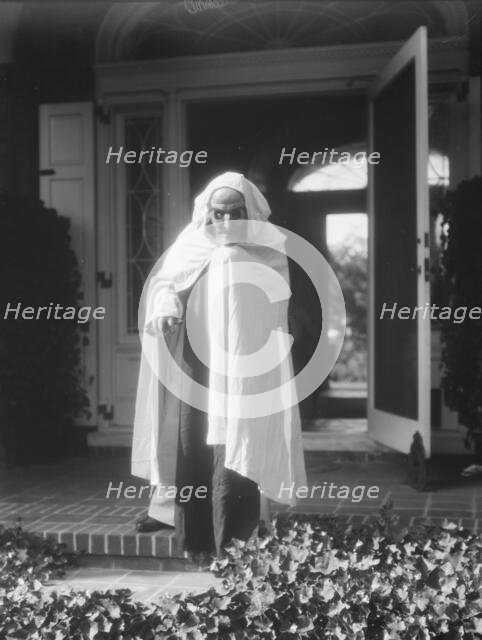 Person wearing a mask made by W.T. Benda, 1925 Sept. 20. Creator: Arnold Genthe.