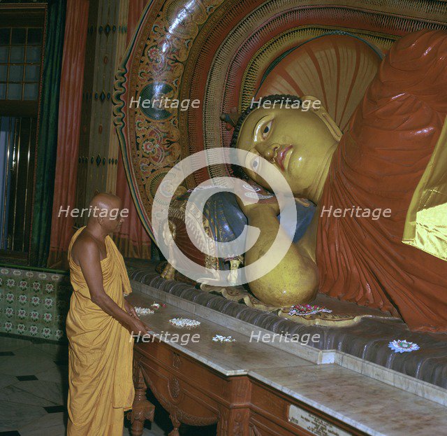 Buddhist priest before the image of a reclining Buddha. Artist: Unknown
