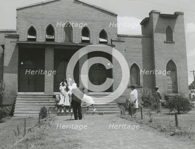 Ushers of an African American church standing on church steps and getting ready to pose..., May 1940 Creators: Farm Security Administration, Jack Delano.