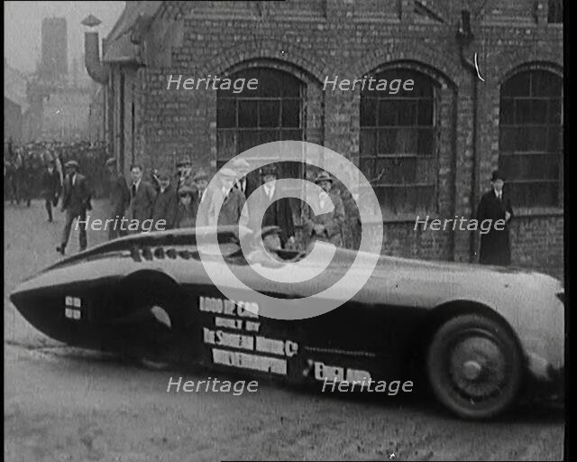Sir Henry Segrave AKA Major Segrave's Driving  'Sunbeam' Out of a Factory Watched By a..., 1927. Creator: British Pathe Ltd.