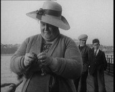 Female Civilian Removing Seaweed from a Fishing Hook Whilst Fishing from a Pier, 1920. Creator: British Pathe Ltd.