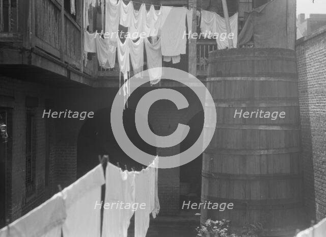 Courtyard with cistern and hanging laundry, New Orleans, between 1920 and 1926. Creator: Arnold Genthe.