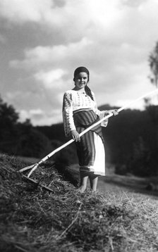 Young woman with a rake, Bistrita Valley, Moldavia, north-east Romania, c1920-c1945. Artist: Adolph Chevalier