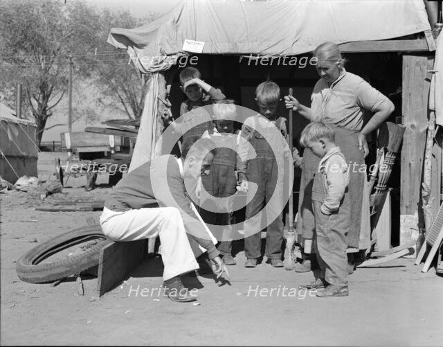 Tom Collins, manager of Kern migrant camp talking with drought refugee and her..., CA, 1936. Creator: Dorothea Lange.