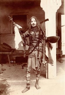 A young Indian man wearing many beads and makeup in a temple precinct, c1900. Creator: Unknown.
