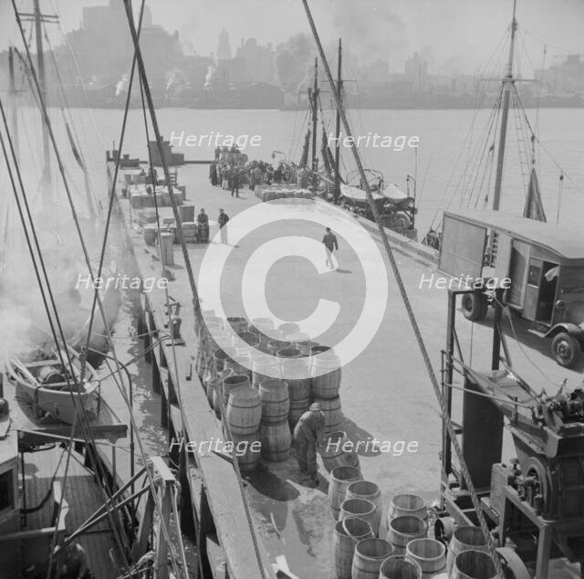 A scene at the Fulton fish market showing the dock where New England fishing, New York, 1943. Creator: Gordon Parks.