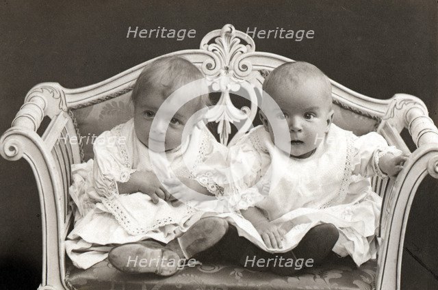 Baby twins on a small sofa. Artist: Unknown