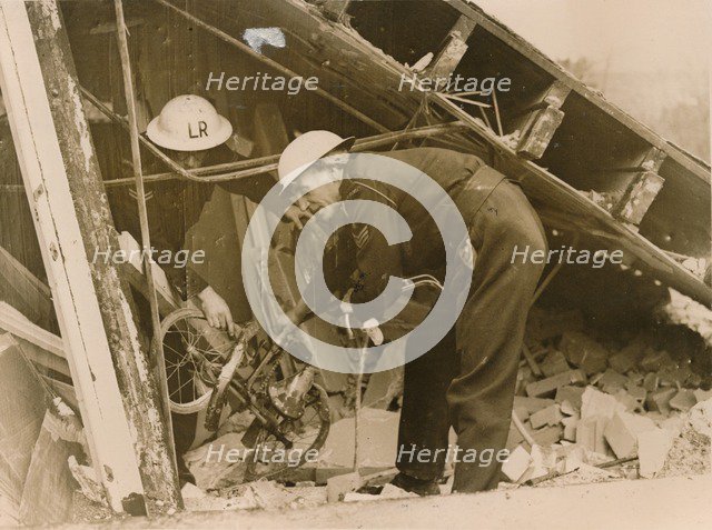 Rescue workers reteieving a bicycle from a wrecked Warden's Post, London. Artist: Unknown