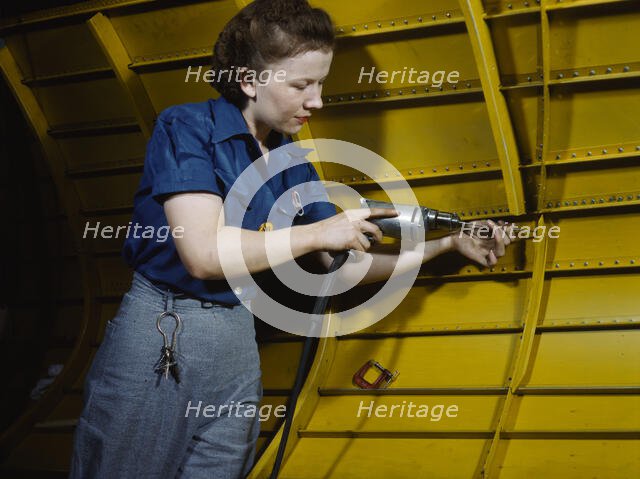 Operating a hand drill at Vultee-Nashville, woman is working on a "Vengeance" dive..., Tenn., 1943. Creator: Alfred T Palmer.