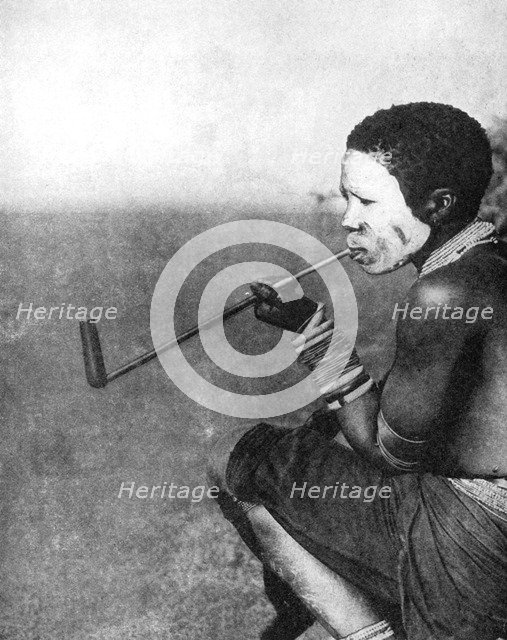 A South African tribesman smoking, 1936.Artist: South African Railways