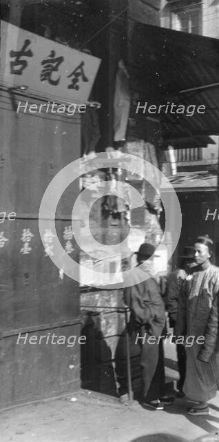 Two men standing on a sidewalk, Chinatown, San Francisco, between 1896 and 1906. Creator: Arnold Genthe.