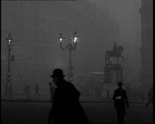 Male Civilians Walking Through the Foggy Streets of London, 1929. Creator: British Pathe Ltd.