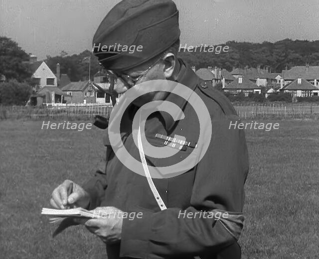 A British Local Defence Volunteer Writing Notes, 1940. Creator: British Pathe Ltd.