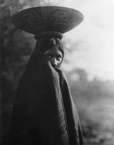 Maricopa girl, half-length portrait, standing, facing slightly right, wrapped in blanket..., c1907. Creator: Edward Sheriff Curtis.