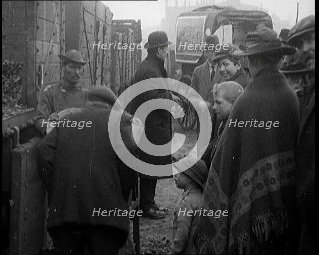 A Group of People Waiting To Receive a Measure of Coal, 1924. Creator: British Pathe Ltd.