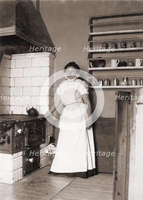 A maid, named Ruth, by the stove, 1905. Artist: Unknown