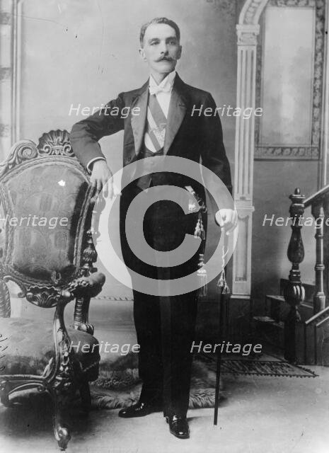 C.E. Restrepo posing next to chair, with cane, 1910. Creator: Bain News Service.