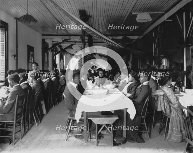 Interior view of dining hall, decorated for the holidays, with students... Tuskegee Institute, c1902 Creator: Frances Benjamin Johnston.