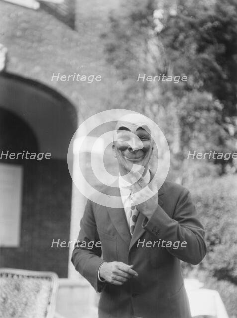 Person wearing a mask made by W.T. Benda, 1925 Sept. 20. Creator: Arnold Genthe.