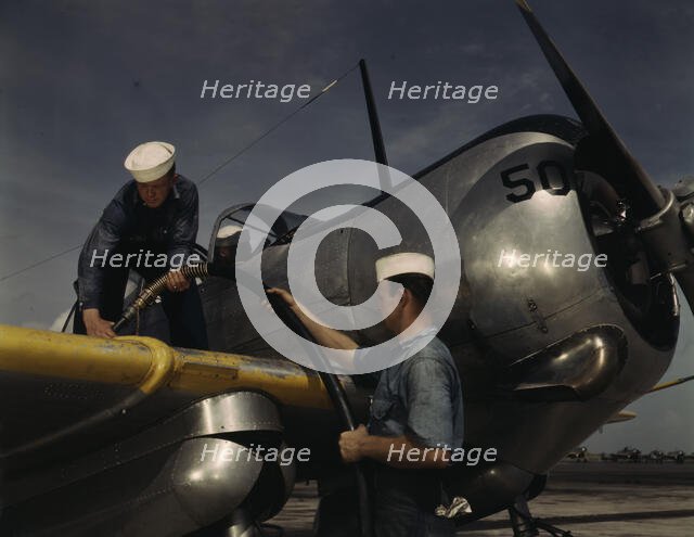 Feeding an SNC advanced training plane its essential supply of gas...Corpus Christi, Texas, 1942. Creator: Howard Hollem.
