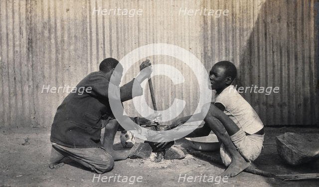 Umtali, Zimbabwe: two African boys stirring a cooking pot, 1905. Creator: J Lomas.