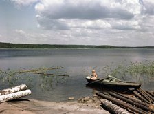 A boy fishing from a rowing boat during his summer holidays, Sweden, 1950s. Artist: Göran Algård