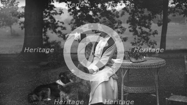 Tarbell, Ida, Miss, with dogs, seated outdoors, 1912 or 1913. Creator: Arnold Genthe.