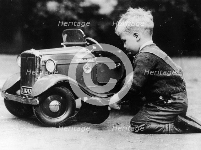 Michael Ware repairing a pedal car. Artist: Unknown