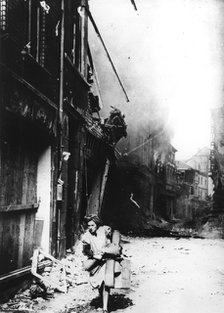 A woman leaving her burning house in a bombed street, Germany, 1945. Artist: Unknown