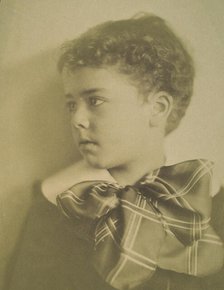 Head-and-shoulders portrait of a young boy with a large plaid bow at the neck of his..., c1900. Creator: Horace L Bundy.