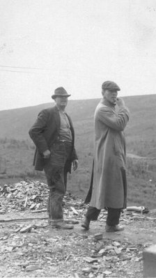 Two men standing near a small pile of rubble, in a field, between c1900 and 1916. Creator: Unknown.