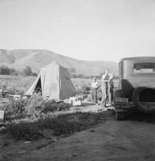 Fatherless migratory family camped behind gas station, Yakima Valley, Washington, 1939. Creator: Dorothea Lange.