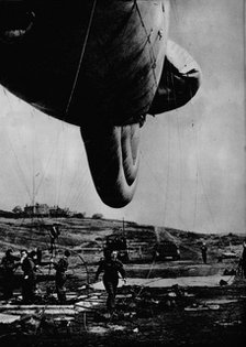 Woman of the WAAF handling a barrage balloon, 1943. Artist: Unknown.