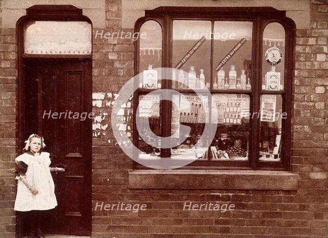 A grocer's shop in England: doorway and shop window, (1900?). Creator: Unknown.