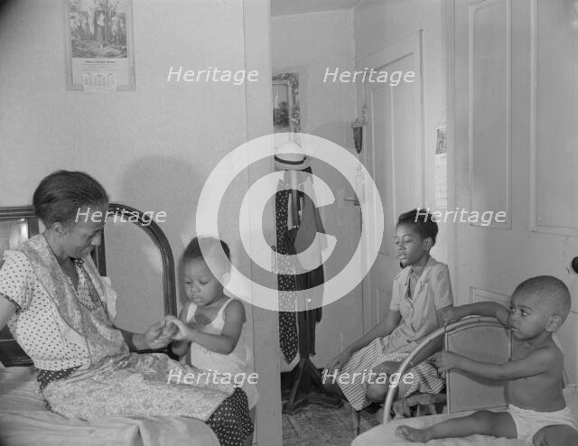 Adopted daughter and two grandchildren with Mrs. Ella Watson...charwoman, Washington, D.C, 1942. Creator: Gordon Parks.
