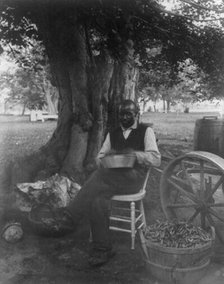 The cook at Marshall Hall, seated outdoors, shelling peas?, c1890. Creator: Frances Benjamin Johnston.