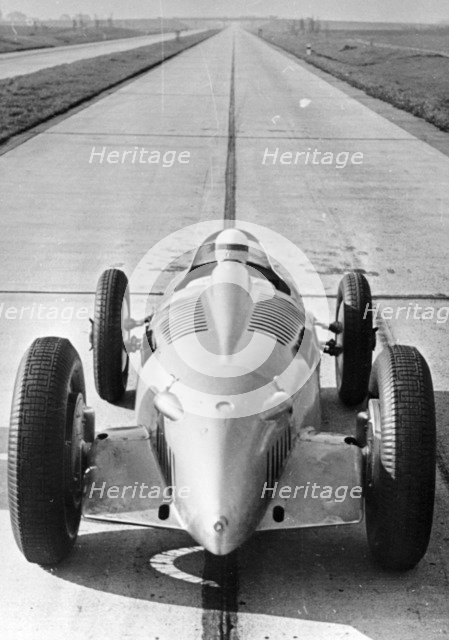 Bernd Rosemeyer in Auto Union record-breaking car, 1937. Artist: Unknown