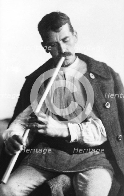 Man playing a wind instrument, Bistrita Valley, Moldavia, north-east Romania, c1920-c1945. Artist: Adolph Chevalier