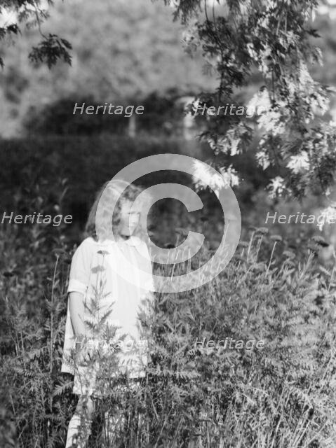 Dunning, Mr., daughter of, standing in a garden, 1925 July 9. Creator: Arnold Genthe.