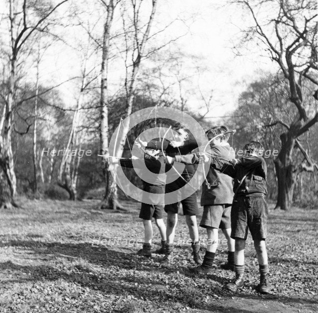 Boys shooting with bows and arrows in Hampstead, London, c1950s. Artist: Henry Grant