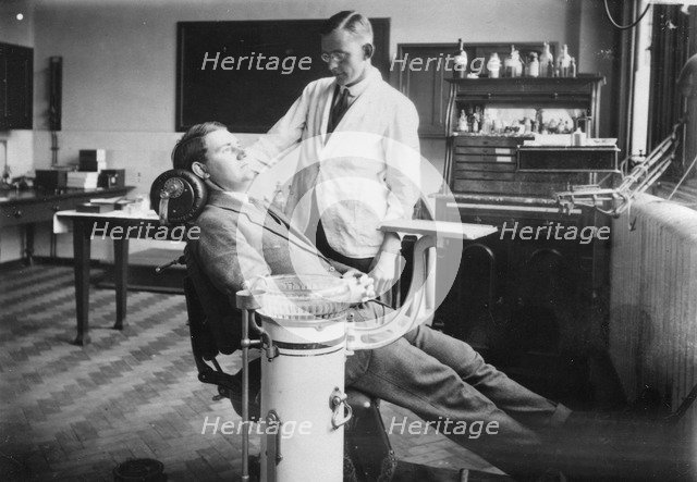 Dentist examines a male patient, Rowntree Factory, York, Yorkshire, 1920. Artist: Unknown