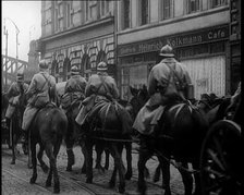 French Soldiers on Horseback Ride Past the 'Heinrich Kolkmann Cafe', 1924. Creator: British Pathe Ltd.