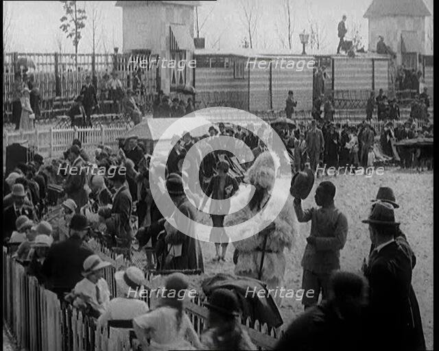 A Crowd of People Watch as Others Ride a Model Train Which Passes Them, 1924. Creator: British Pathe Ltd.